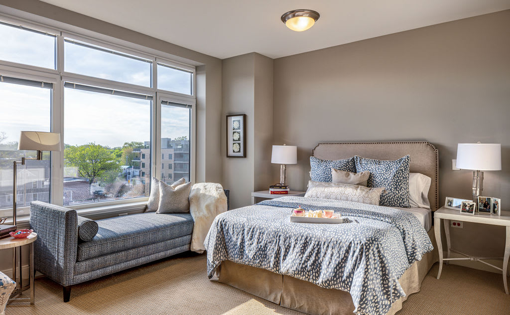 A cozy bedroom featuring a comfortable bed, window seat, and stylish decor.