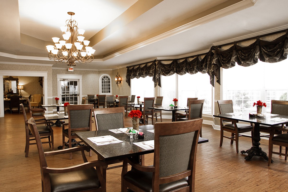 A spacious dining area with elegant lighting and neatly arranged tables and chairs.