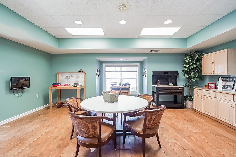 A cozy dining room with a round table and chairs, featuring a piano and soft lighting.