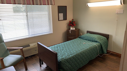 A cozy and well-lit bedroom featuring a single bed neatly made with light blue bedding.