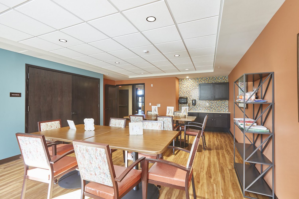 A modern meeting room with a large conference table and chairs, featuring a sleek interior design.