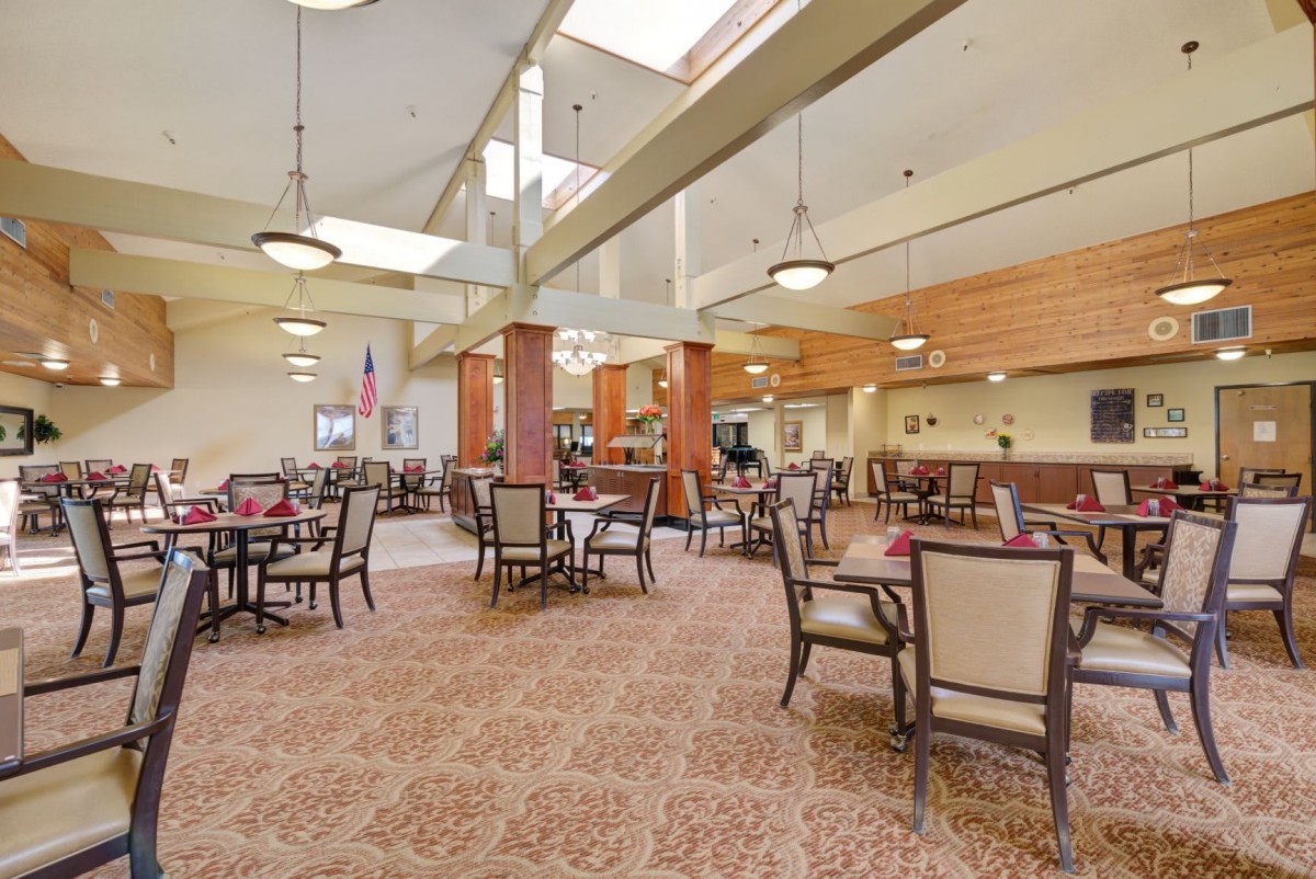 A spacious dining area with elegant furnishings and ambient lighting.