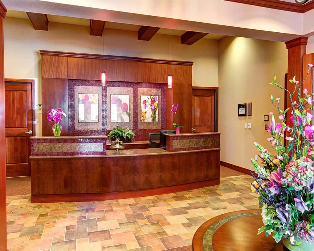 A welcoming reception area with a wooden counter and floral decor.