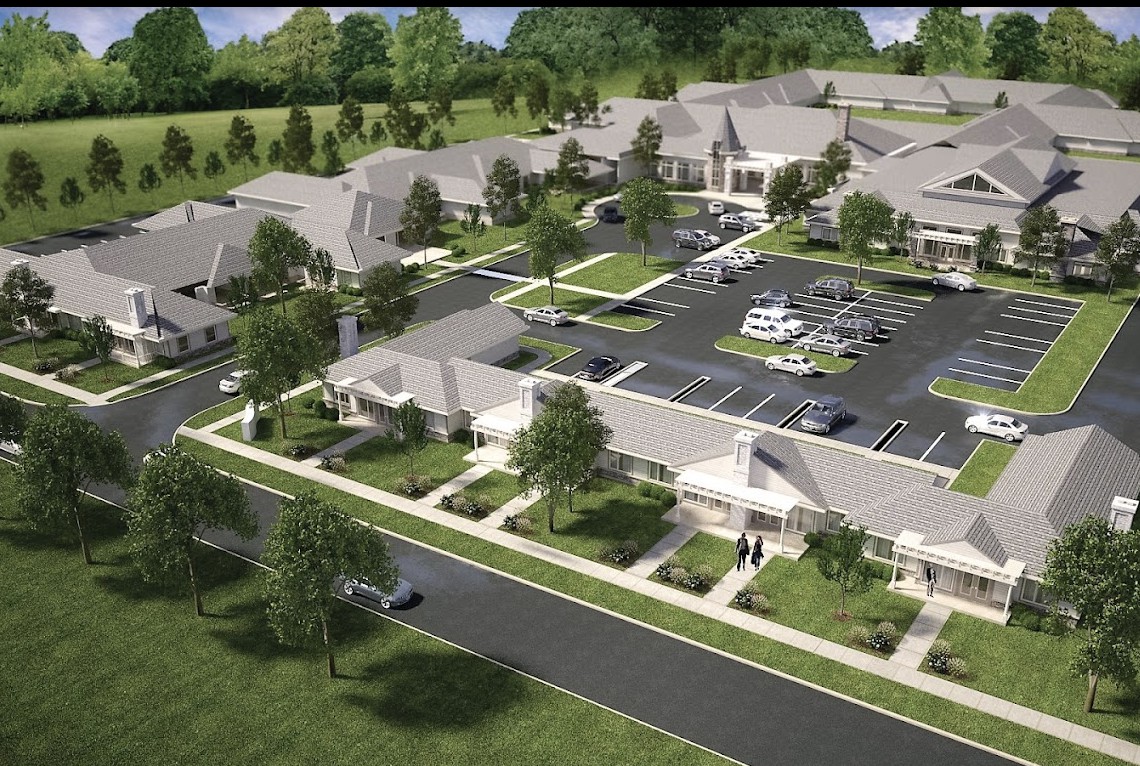 Aerial view of a residential complex with landscaped grounds and parking facilities.