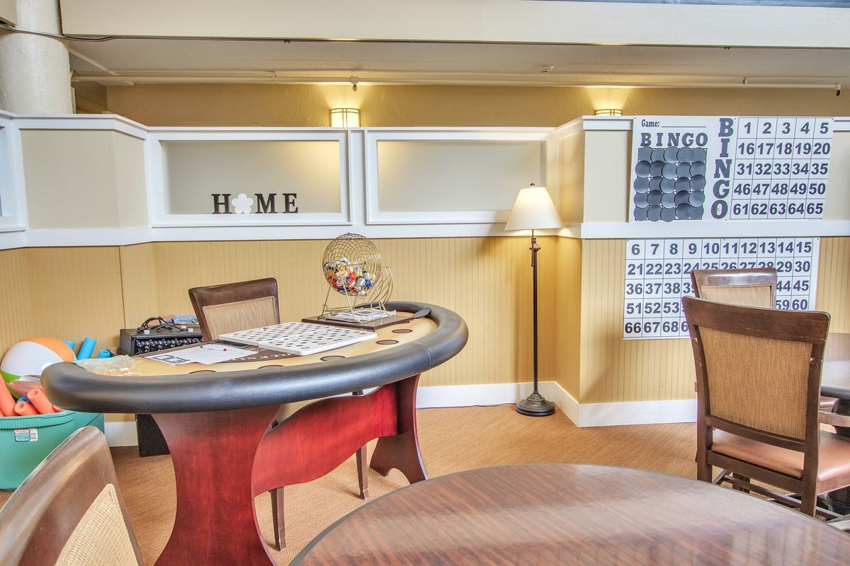 A cozy interior space featuring a table, chairs, and decorative wall art.