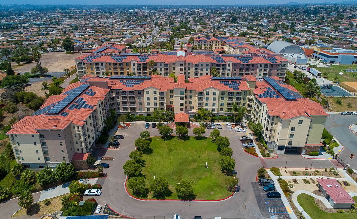 An aerial view of a large residential complex with a central courtyard surrounded by buildings.