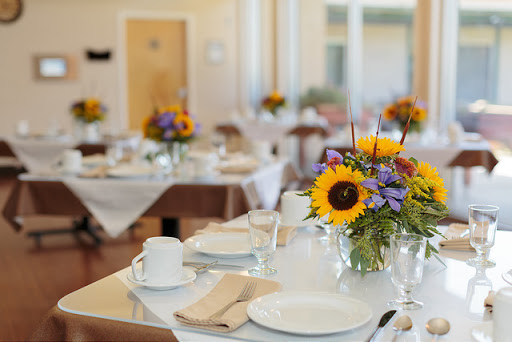 A beautifully arranged dining table featuring vibrant sunflowers and elegant tableware, perfect for a special event.