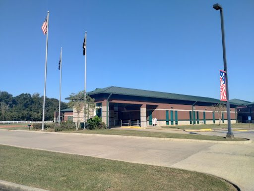 A view of a building with several flags under a clear blue sky.