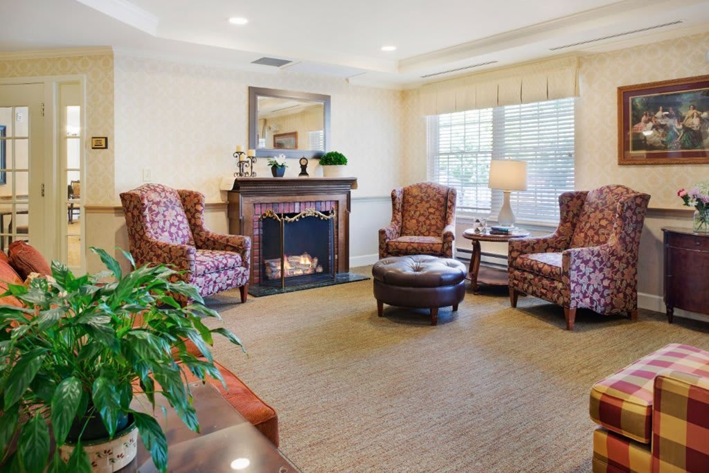 A cozy living room featuring armchairs, a fireplace, and a coffee table.