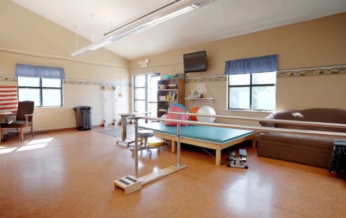 A bright and spacious rehabilitation room equipped with exercise and therapy equipment.