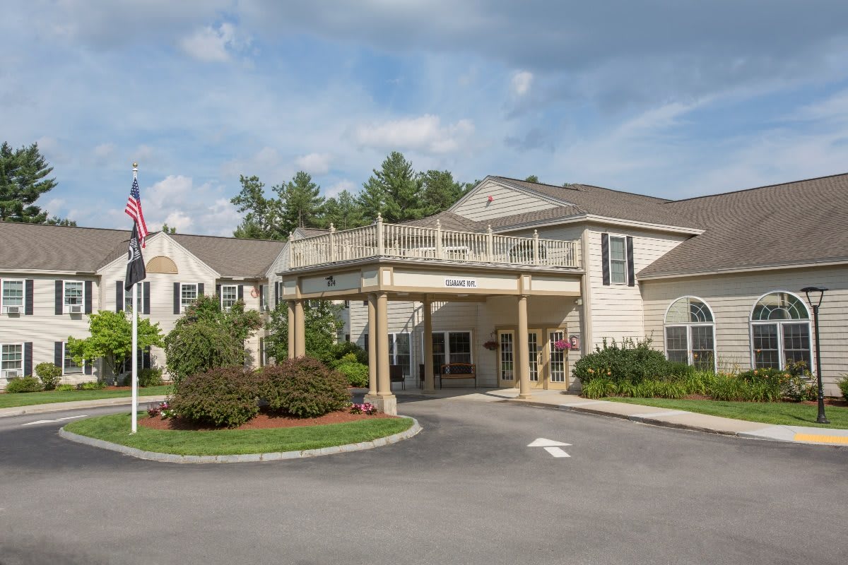 A scenic view of a residential building entrance with landscaped surroundings.