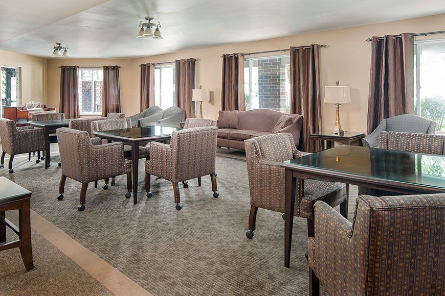 A cozy living room with tables, chairs, and a sofa.