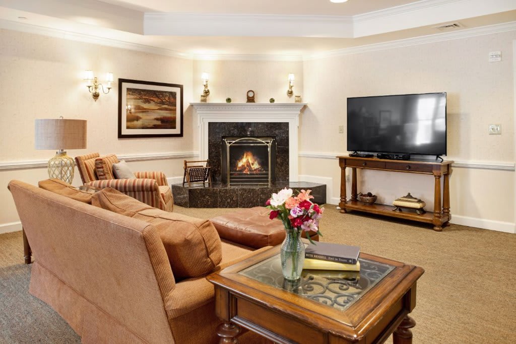 A cozy living room with a fireplace, comfortable sofa, and a large television.