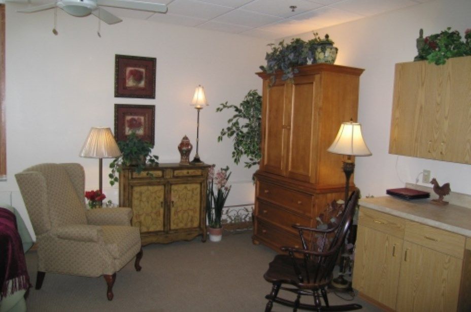A cozy living room with various pieces of furniture and decorative elements.