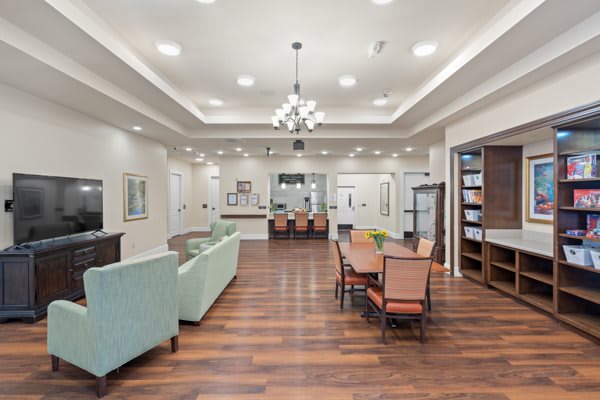 A spacious, modern living and dining area with elegant furnishings and wood flooring.