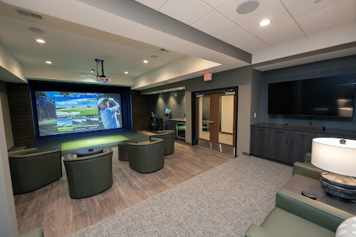 A modern lounge area featuring comfortable seating and a large projection screen for entertainment.