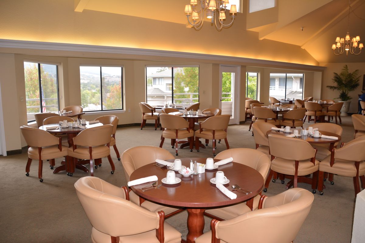 Elegant dining room with neatly arranged tables and chairs, offering a well-lit and welcoming atmosphere.