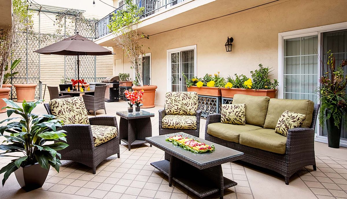 A cozy patio with stylish outdoor furniture and vibrant plant decorations.