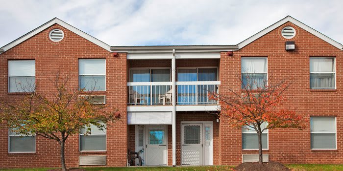 A two-story brick apartment building with balconies.