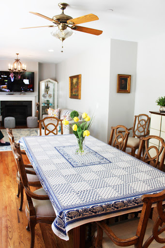 A beautifully arranged dining room featuring a large table with a floral centerpiece and comfortable seating.