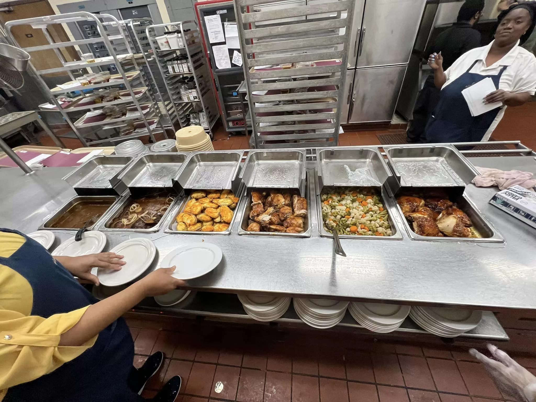 A cafeteria buffet line with various dishes in trays ready to be served.