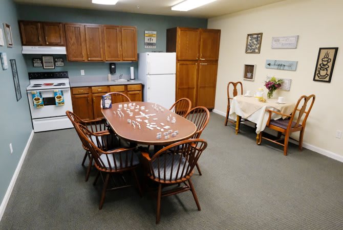 A cozy kitchen and dining area featuring a wooden table with chairs, cabinetry, and essential appliances.
