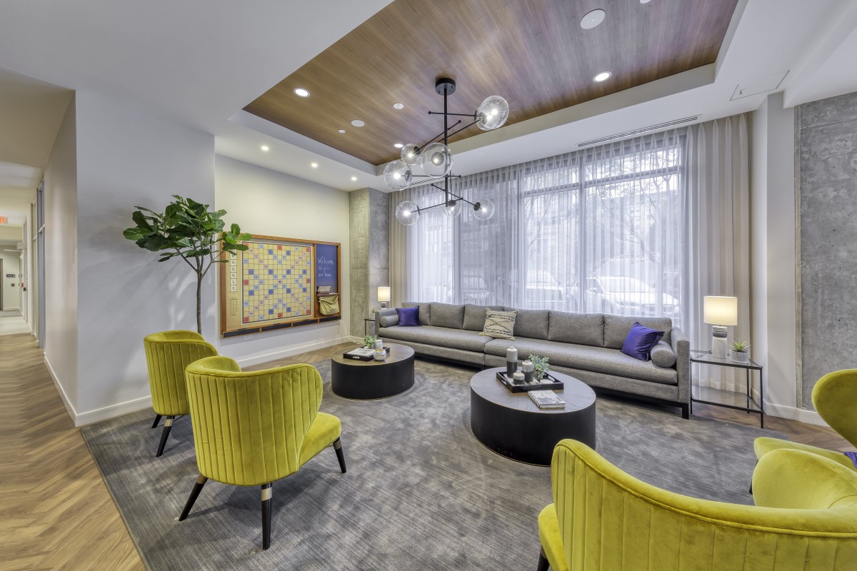 A chic living room with modern decor, featuring yellow chairs and a gray sofa.