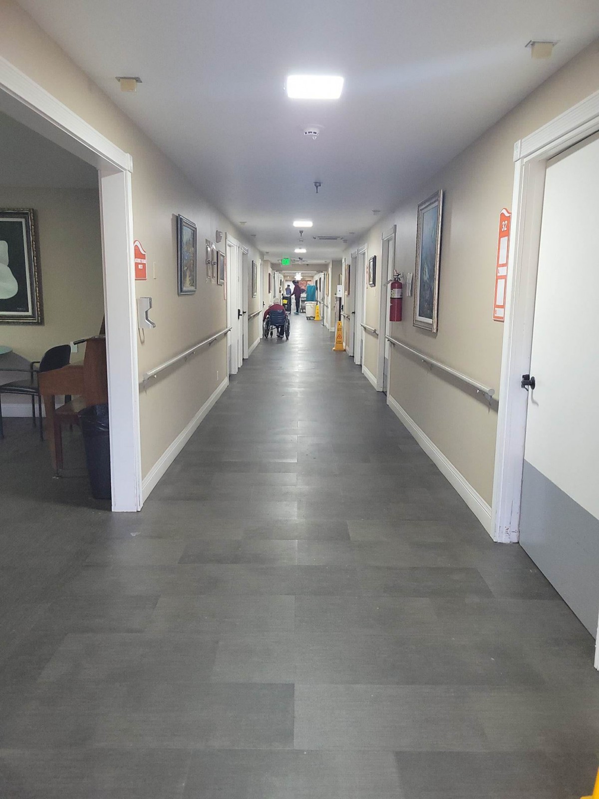 A long, well-lit hallway typically found in healthcare facilities.