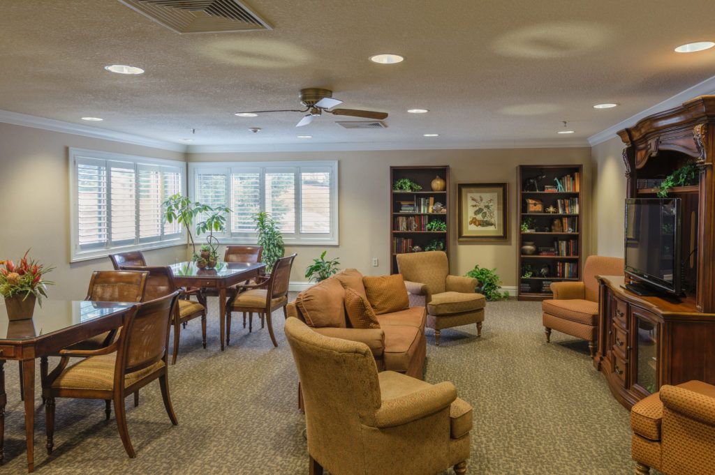 A cozy living room with comfortable seating, bookshelves, and a dining area.