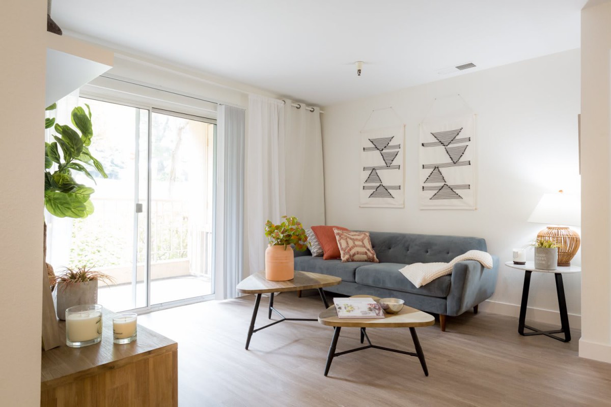 A modern living room with a stylish sofa and coffee table, complemented by geometric artwork and a cozy atmosphere.