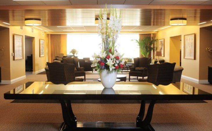 A well-decorated lobby area featuring a central table with a flower arrangement in a vase.