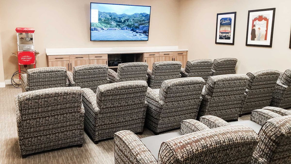 A cozy home theater setup with multiple recliners and a large screen television.