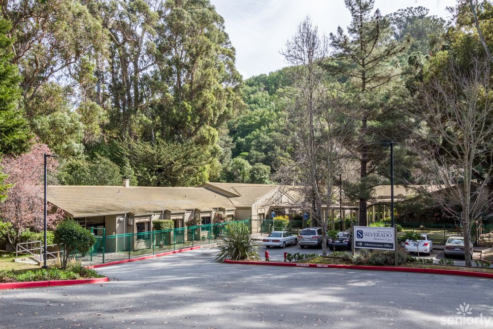 A serene entrance to a building surrounded by trees and greenery.