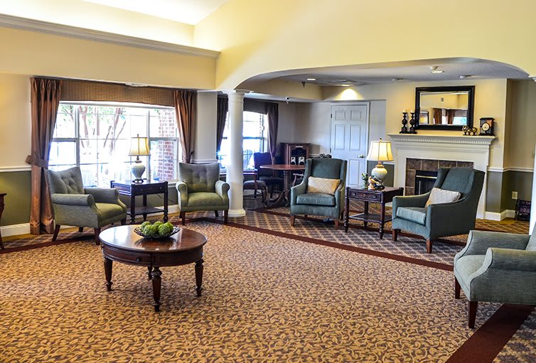 A cozy living room with comfortable chairs, a central table, and warm lighting.