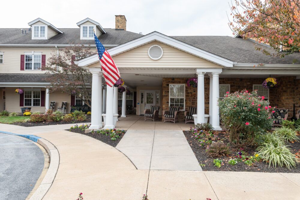 The entrance of a building with white columns and an American flag.