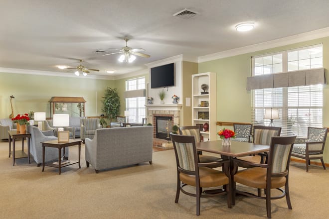 A cozy living room with a dining area, featuring a sofa, television, and fireplace.