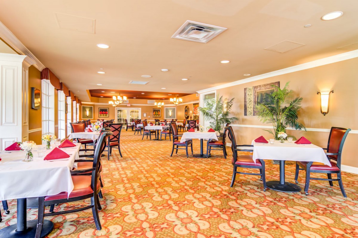 A spacious and elegantly decorated restaurant dining area with neatly arranged tables and chairs.