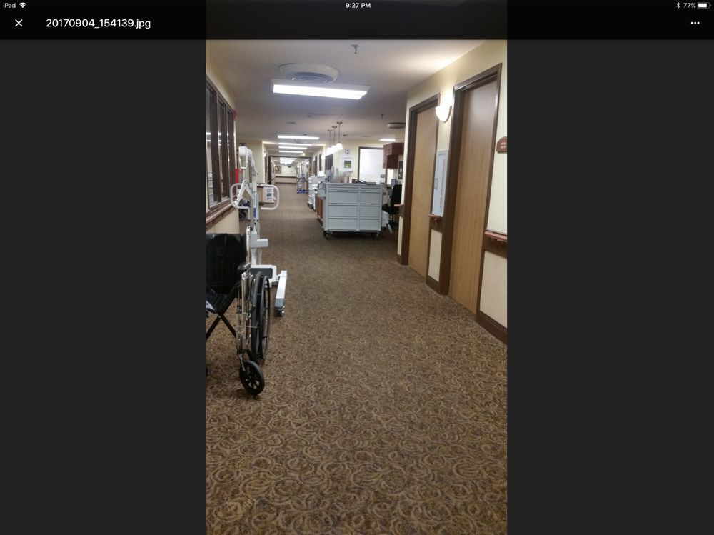 A hospital corridor with medical equipment and doors on either side.
