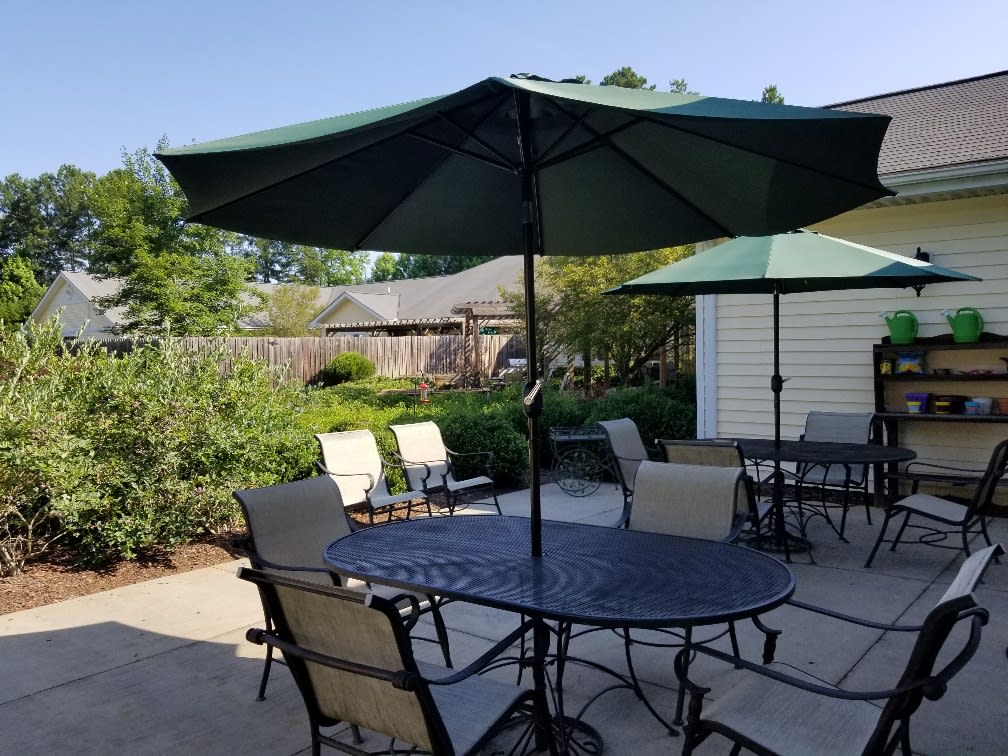 A patio with outdoor furniture featuring tables, chairs, and umbrellas.