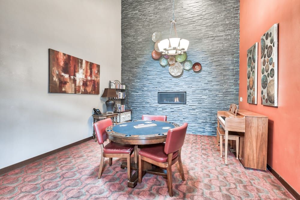 A stylish dining area with a central table and chairs, accented by a fireplace and a piano.