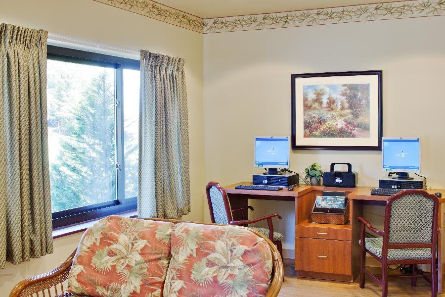 A cozy office space with a desk, computer, and a comfortable sofa.