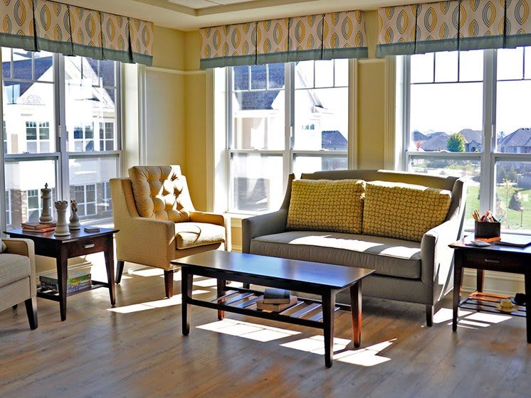 A sunny living room with a sofa, armchair, and coffee table.