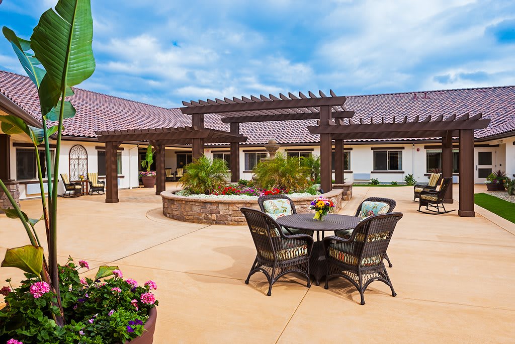 A spacious outdoor courtyard with seating and a pergola on a sunny day.