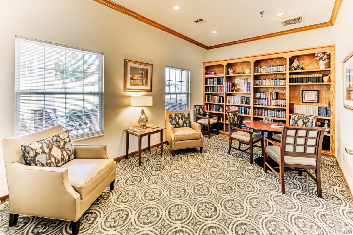 Cozy library reading area with bookshelves and comfortable seating.