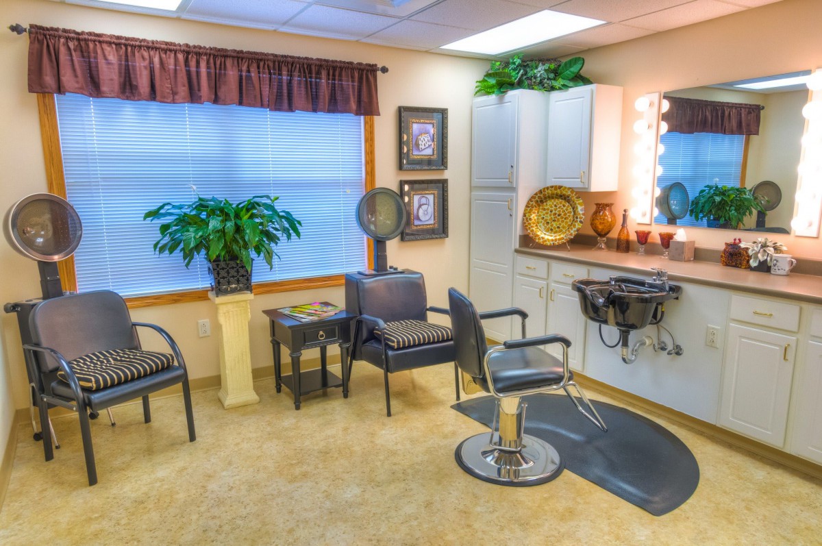 A cozy and well-decorated hair salon interior with chairs, a large mirror, and various decor items.