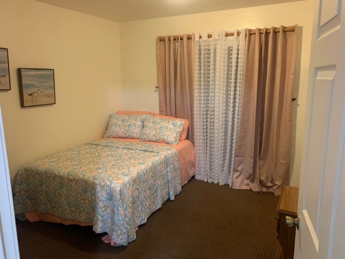 Cozy bedroom with floral bedding and soft lighting.