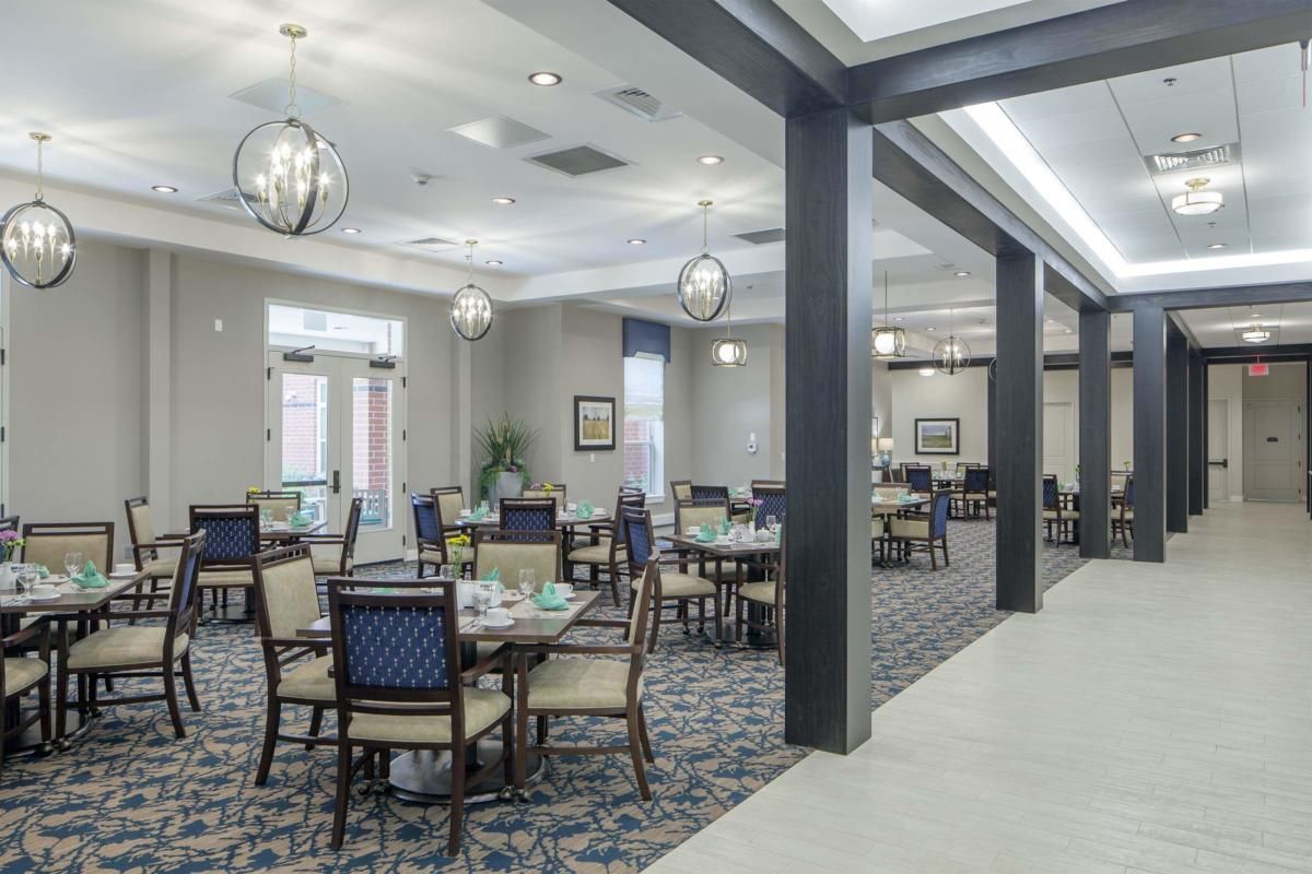 A spacious and elegantly decorated dining area with modern lighting and neatly arranged tables and chairs.