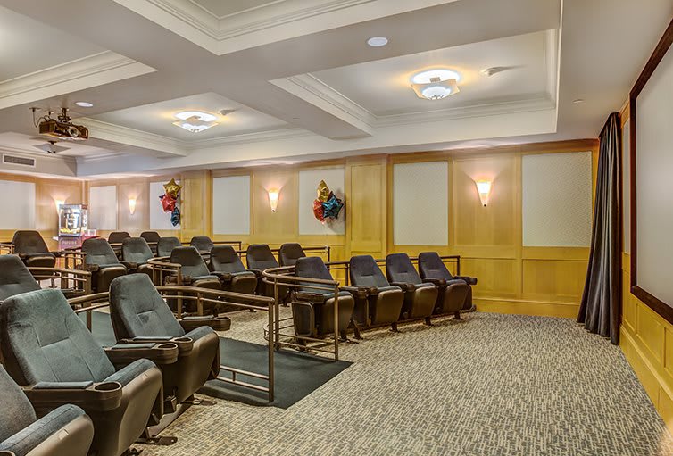 An empty theater room with rows of comfortable seating.
