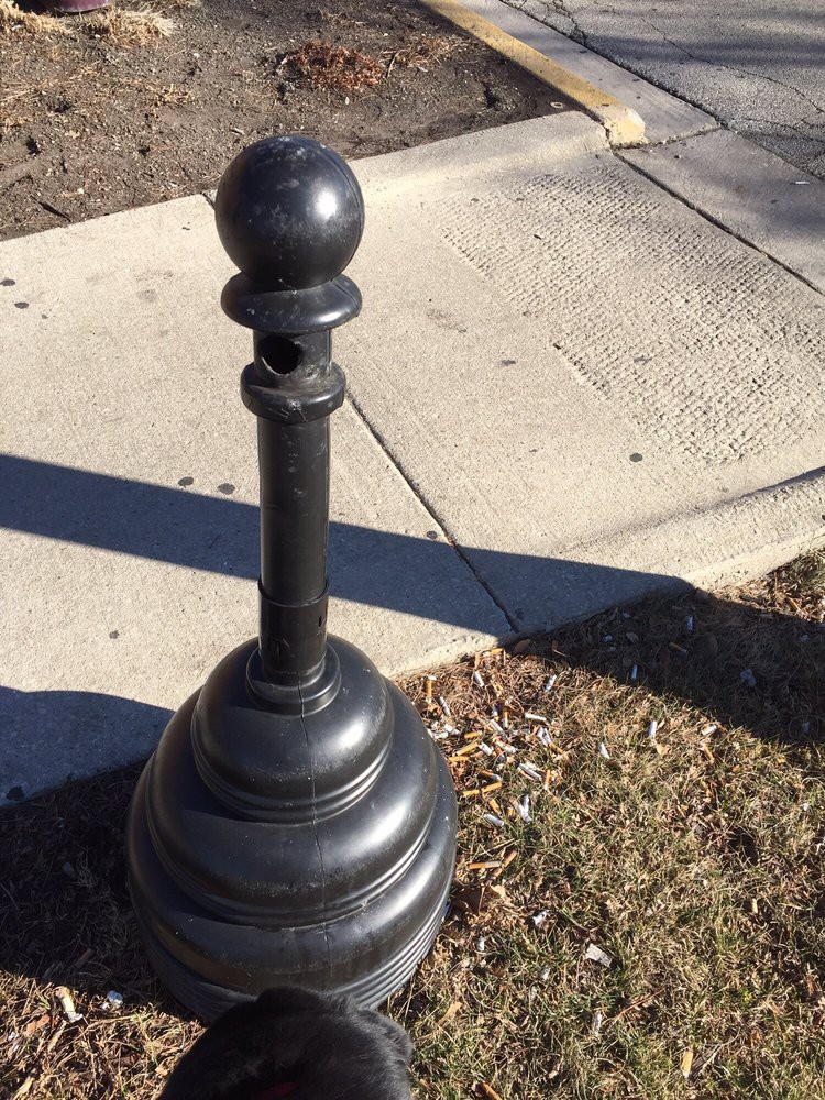 A decorative bollard on a city sidewalk.