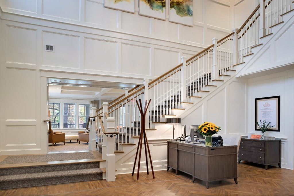 A spacious and elegantly designed foyer with a grand staircase leading to the upper level, showcasing classic architectural elements and stylish decor.